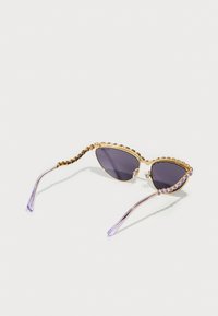Occhiali da sole dorati con lenti viola. Presentano una montatura dorata decorata con perline e punte lilla. Elegante forma a occhio di gatto.