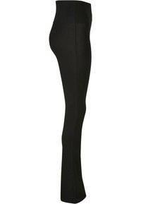 Leggings noirs taille haute, fabriqués à partir d'un tissu extensible. Présentent une texture lisse et un design ajusté, se rétrécissant jusqu'à la cheville.