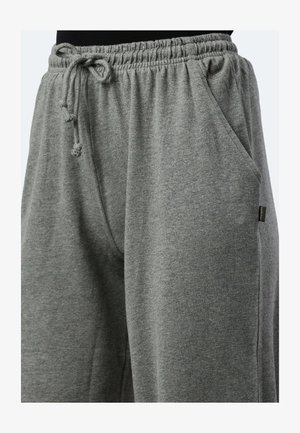 Graue Jogginghose mit einem elastischen Bund und Kordelzug, seitlichen Taschen und einem weichen, strukturierten Stoff. Kleines Markenetikett an der Seite.