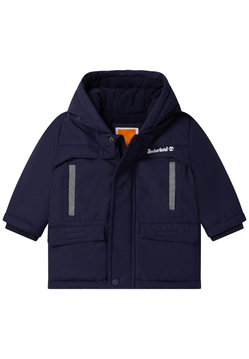 Chaqueta de invierno para niños en azul marino con capucha, bolsillos frontales, tiras reflectantes y el logo de Timberland en el pecho.