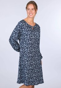 Marineblaues Kleid mit langen Ärmeln, florales Muster in Hellblau, runder Ausschnitt mit Schlitzdetail, fließender Stoff, knielanges Design.