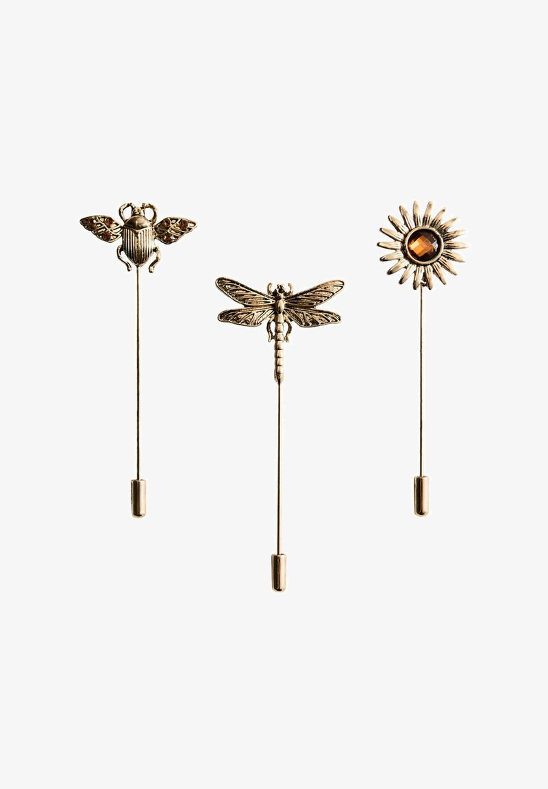 Trois épingles en métal doré avec des têtes décoratives : une abeille, une libellule et un soleil avec un centre en pierre couleur ambre.