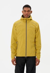 Veste imperméable jaune avec capuche, dotée de poches zippées et d'accents réfléchissants. Texture lisse et design léger, idéale pour une utilisation en extérieur.