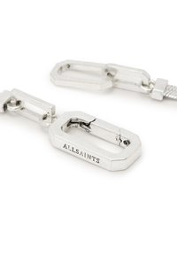 Attache en métal argenté de forme octogonale, gravée "ALLSAINTS," avec une surface texturée et un design de lien de connexion.