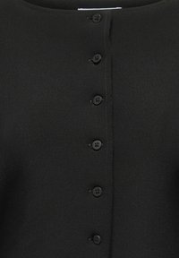 Vêtement noir à boutons avec six boutons ronds noirs répartis uniformément sur le devant et un col arrondi.