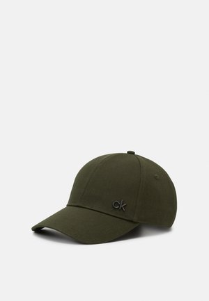 Mørkegrøn baseballkasket med buet skygge og lille sort "ck" logo på fronten, vist på en lysegrå baggrund.