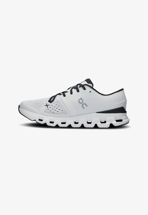 Scarpa da corsa bianca con lacci neri, dettagli neri sul tallone, suola segmentata ammortizzata e tomaia in mesh traspirante con logo del marchio sul lato.