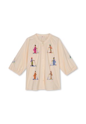 Beige blouse met knopen en kleurrijke geborduurde figuren die op scooters rijden en traditionele kleding dragen, met driekwart pofmouwen.