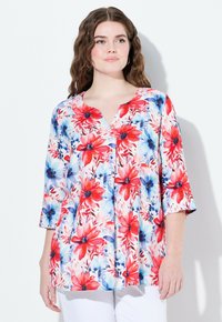 Blommig blus med V-ringning och 3/4 ärmar. Har röda och blå blommor på vit bakgrund, lättviktsmaterial, lös passform.
