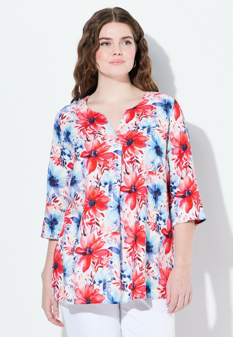 Blommig blus med V-ringning och 3/4 ärmar. Har röda och blå blommor på vit bakgrund, lättviktsmaterial, lös passform.