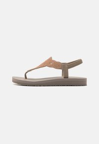 Vaaleanruskeat flip-flop-sandaalit, joissa on teksturoitu, kimalteleva vaaleabeige hihna ja tasainen pohja. Varustettu kestävästä kumista valmistetulla ulkopohjalla pitävän otteen saamiseksi.