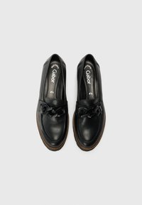 Zapatos de cuero negro con punta redondeada, que presentan un detalle de cinta trenzada y costuras en contraste a lo largo de la suela. Marca Gabor visible en el interior.