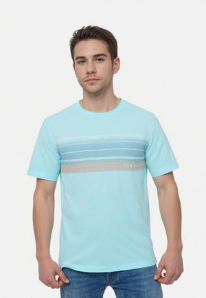 Light blue striped t-shirt made of soft fabric. Features horizontal bands in darker blue and beige, with branding on the front.