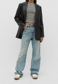 Czarna marynarka z ekoskóry, paskowana krótka bluzka, jasno-niebieskie spodnie typu wide-leg oraz białe sneakersy z beżowymi akcentami. Minimalistyczny design i casualowy styl.