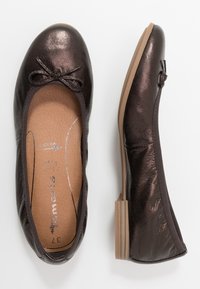 Ballerine marroni scure con una finitura metallica, punta arrotondata, tacco sottile e un accento a fiocco sul davanti. Parte superiore in pelle textured e soletta liscia.
