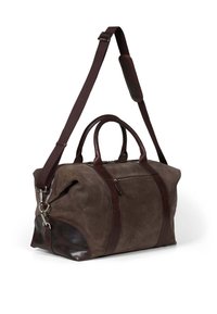 Sac de voyage en daim marron avec des accents en cuir noir, poignées doubles, bandoulière amovible et poche zippée à l'avant.