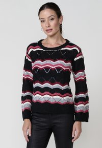 Pull en maille avec une base noire et des motifs en zigzag rouge, rose et gris. Col rond, manches longues et détails texturés.
