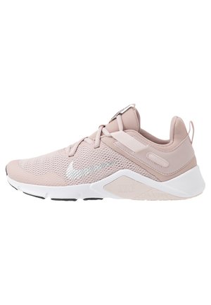 Lyserød Nike sneaker med mesh-overdel, polstret hvid sål, snørelukning og sølvfarvet Nike-swoosh på siden.