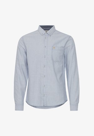 Maglietta a maniche lunghe a righe in blu chiaro e bianco, con bottoni davanti, taschino singolo sul petto e orlo arrotondato. Il materiale sembra leggero e traspirante.