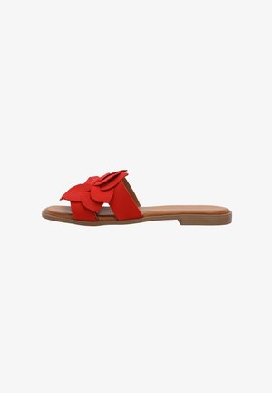 Rød flad sandal med bred rem med lagdelte blomsterlignende detaljer, brun sål og åben tå, set fra siden.