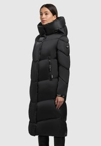 Schwarzer Steppmantel mit hohem Kragen, gestepptem Design und Reißverschlusstaschen. Verfügt über ein Logo am Oberarm und eine schlanke, verlängerte Silhouette.