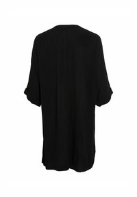 Chemise noire ample à manches courtes roulées, fabriquée en tissu léger, avec un design simple et sans ornements, et une coupe décontractée.