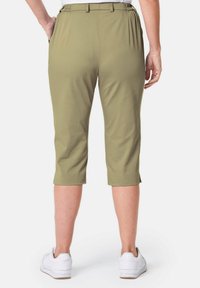 Olivgrüne Caprihosen mit lockerer Passform, elastischem Bund und Seitentaschen, kombiniert mit weißen Sportschuhen.