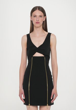 Black fitted dress with a twisted bodice design, featuring a deep V-neck and gold zipper details running vertically down the front.