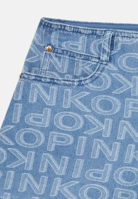 Denim shorts in light blue featuring an all-over logo print. Includes a front pocket and gold button detail. Textured, casual design.