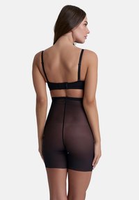 Svart shapewear bodysuit med justerbara band, en krok-och-öga bakknäppning och semi-genomskinlig textur som formar midjan och höfterna.