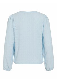 Lyseblå bomullsskjorte med lange ermer, som har et strukturert hullmønster og rynkede mansjetter. Rund hals med en rett kant.