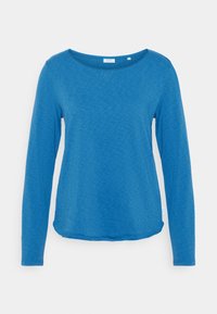 Košile s dlouhým rukávem v jasně modré barvě, vyrobená z texturované látky, s širokým výstřihem a zaobleným lemem. Štítek na boku.