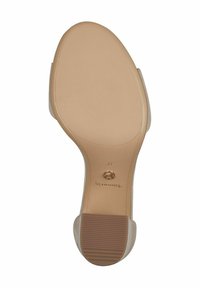 Beige High Heels Sohle mit strukturiertem Muster. Verfügt über eine abgerundete Form, glatte Kanten und ein kleines metallisches Akzent nahe dem Absatz.