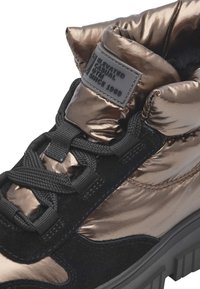 Zapatillas metálicas en bronce y negro con cuello acolchado, superficie texturizada, cordones oscuros y suela de goma; cuenta con etiqueta de la marca en la lengüeta.