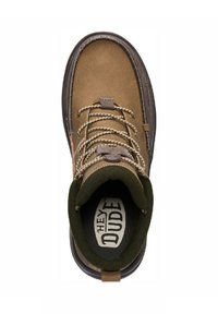 Scarpa in suede marrone con colletto imbottito verde, lacci marroni e suola scura strutturata. Logo visibile sulla soletta.