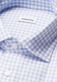Colletto di camicia in cotone a quadri azzurri e bianchi con etichetta "seidensticker", dotato di chiusura a bottone e tessuto morbido.