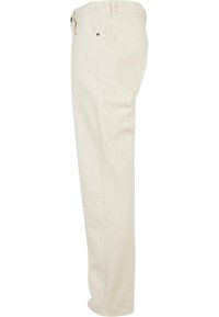 Pantalons en coton beige avec une coupe droite, dotés de deux poches latérales et de poches arrière, avec des coutures visibles le long des coutures.
