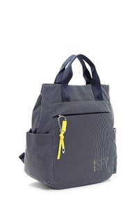 Mörkblå tygväska med prickigt mönster, ovandelshandtag, sidoficka, gul accent med karbinhake och blixtlåsförsett framfack.