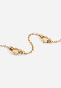 Bracciale in oro con ovali intrecciati e una texture liscia, impreziosito da piccole pietre trasparenti su due anelli.