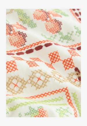 Biely textil s prepracovanou výšivkou v oranžovej, zelenej a hnedej farbe, so geometrickými vzormi a krížikovou výšivkou rozdelenou po celom povrchu.