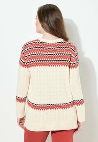 Maglione a cable knit crema con motivi geometrici arancioni e neri, con polsini e orlo a coste. Presenta un colletto rotondo e maniche lunghe.