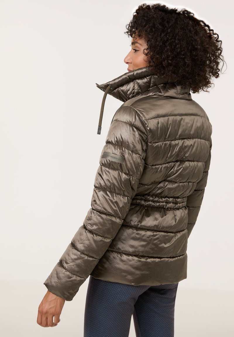 Olivgrüne Puffjacke mit hohem Kragen, tailliertem Schnitt und horizontaler Steppoptik. Hergestellt aus glänzendem, leichtem Material.