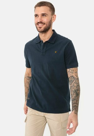 Navy polo shirt made of cotton, featuring a two-button collar, embroidered logo in yellow, and short sleeves. Plain fabric with no patterns.