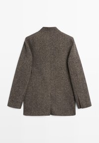 Brown tweed jacket with a structured design, notched collar, and two side slits. Textured fabric with a subtle pattern. Rear view.