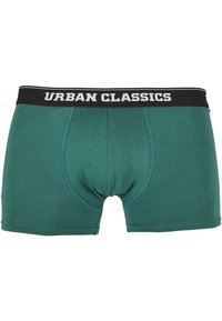 Boxers pour hommes en teal, fabriqués en tissu doux avec un design ajusté. Dotés d'une taille élastique noire avec "URBAN CLASSICS" en texte blanc.