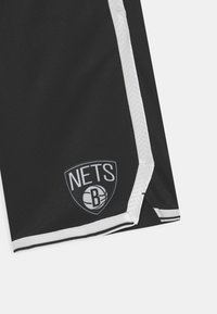 Musta urheilushortsit, joissa valkoinen raita ja harmaa "Nets"-logo sekä koripallokuvio. Valmistettu hengittävästä, kevyestä materiaalista.