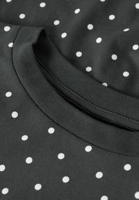 Zwart katoenen t-shirt met witte stippen, geribde ronde hals, gestructureerd oppervlak en netjes gestikte randen.