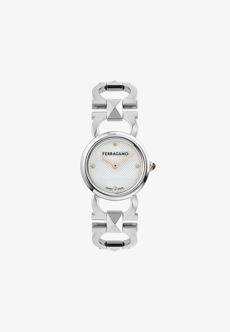 Srebrny zegarek metalowy z okrągłą, białą, teksturowaną tarczą, logo i diamentowymi akcentami. Pasek zegarka zdobią ze sobą powiązane kształty architektoniczne.
