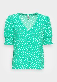 Blusa verde de manga curta com decote em V, apresentando bolinhas brancas, punhos franzidos e detalhe frontal com botões.