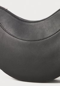 Black leather crescent-shaped handbag with smooth texture and a zip closure. Features curved design and subtle stitching details.